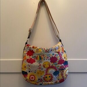Lily Bloom floral hobo-style purse features a colorful sunshine and cloud print.